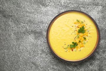 Delicious creamy corn soup on grey table, top view. Space for text