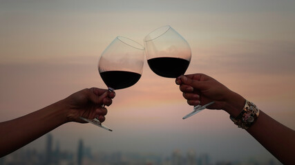 Happy Romantic of  couple or friendship which happy moment relaxing ,red,wineglass,celebration on the rooftop in the night with bokeh background