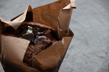 Photo A chocolate muffin on a dark stone board. Delicious pastries
