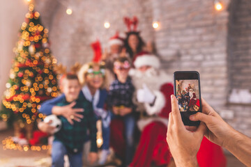 Fototapeta na wymiar Family taking photos with Santa Claus