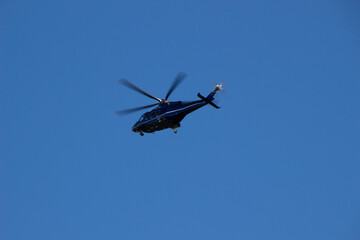 Photo of flying helicopter against blue sky