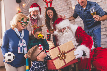 Family opening Christmas presents with Santa Claus