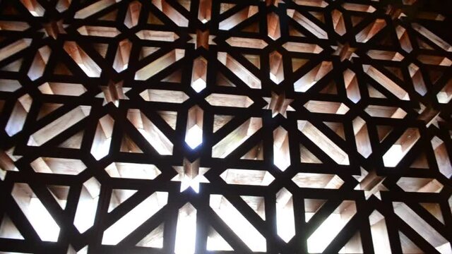 Light streaming through screens perforated with Islamic geometric patterns
