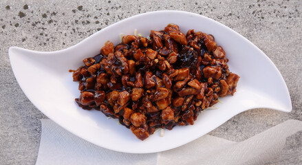 Fried chicken meat with soy sauce and walnuts