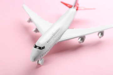 Toy airplane on pink background, closeup view