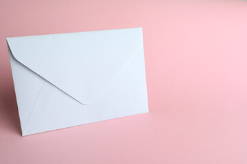 White paper envelope on pink background. Space for text
