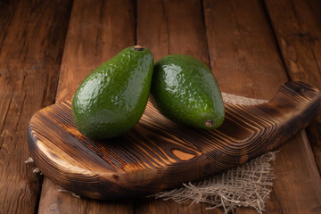 Eco vegetables - fresh avocado on wooden background, vegan food