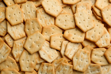 Many delicious crackers as background, top view