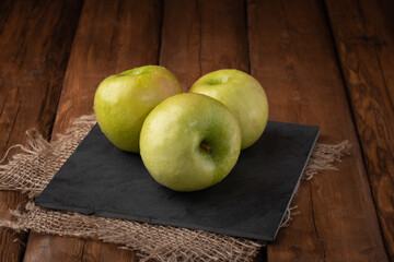 Eco fruits - fresh green apples on wooden background, vegan food