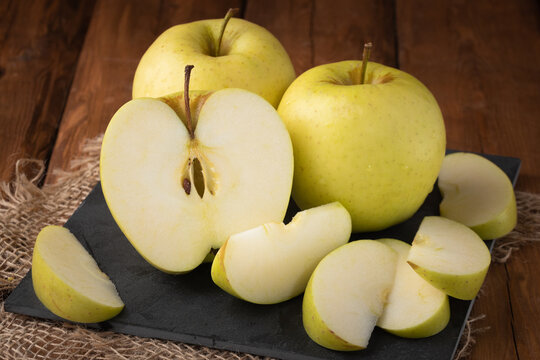 Eco fruits - fresh yellow apples on wooden background, vegan food