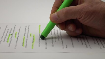 Man highlights lines of text with a green wax-like highlighter