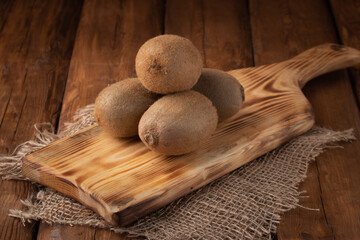 Fototapeta na wymiar Eco fruit - fresh kiwi on wooden background, vegan food