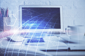 Double exposure of desktop with computer and world map hologram. International data network concept.