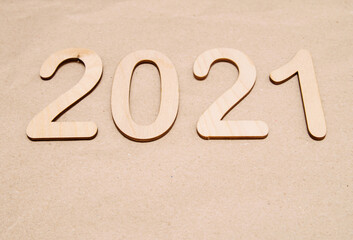 Light wooden numbers 2021 lie centered on craft paper