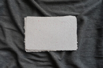 A set of handmade paper sheets lies on a gray surface. Paper recycling and zero waste concept.