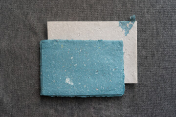 A postal set of handmade envelopes and sheets of paper lie on a gray surface. Paper recycling and zero waste concept.