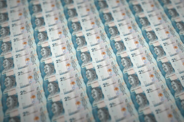 2 Colombian pesos bills printed in illegal money production conveyor. Collage of many fake bills....