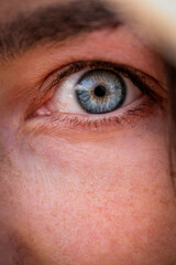 Close-up of the blue eye of a female. Intens looking at the camera. High quality photo