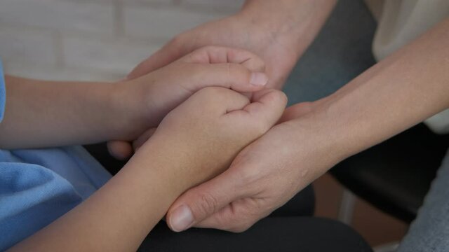 Mother support child in the family. A view of a mother's hand supporting her little girl in the room.