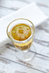 Glass of beer on bright wooden background.