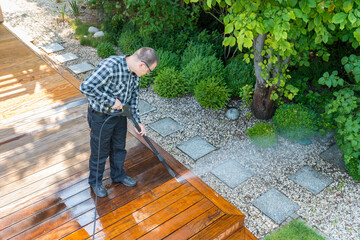 power washing - man cleaning terrace with a power washer - high water pressure cleaner on terrace...