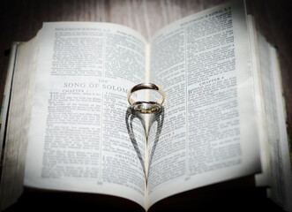 Wedding ring and heart shadow in bible