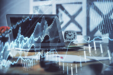 Stock market chart hologram drawn on personal computer background. Double exposure. Concept of investment.