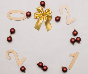 Naklejka na ściany i meble Light wooden numbers 2021 are scattered on a white background in a circle with Christmas balls and a golden bow