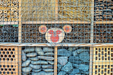 A background of many different natural materials filling the cells of the stand. A stand for demonstrating and studying insects is behind the net