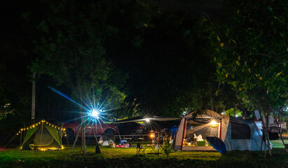 Camping and tent on green grass with lamp in nature park at night