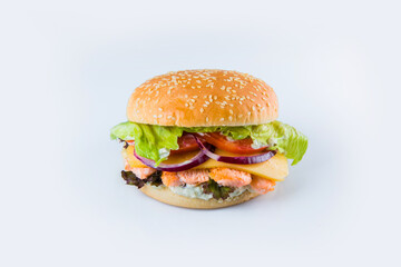 Salmon burger with vegetables and cheese in wheat bun with sesame seeds. Fish Burger with fresh salad leaves, tomatoes, Spanish onions isolated on white background. Food Isolation restaurant menu