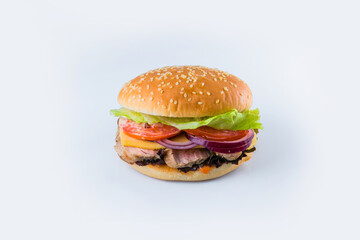 Pork burger with vegetables and cheese in wheat bun with sesame seeds. Meat Burger with fresh salad leaves, tomatoes, Spanish onions and sauce isolated on background. Food Isolation restaurant menu

