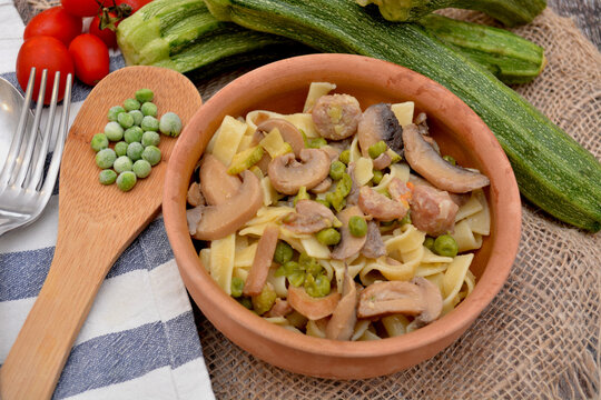 tagliatelle alla boscaiola cibo italiano con salsiccia di maiale funghi zucchine piselli