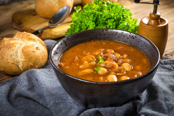 Beans with tomato sauce, bacon and sausage.
