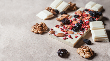White chocolate bar with dried berries with almonds and raisins in macro