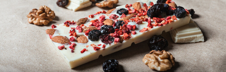 White chocolate bar with dried berries with almonds and raisins in macro