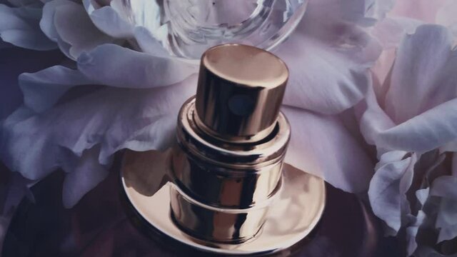 Purple perfume bottle with peony flowers, chic fragrance scent as luxury cosmetic, fashion and beauty product background, stock footage