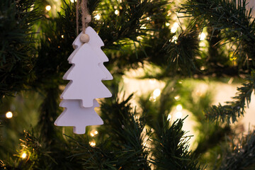 Fir-shaped decoration in white, hanging from the Christmas tree.