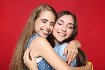 Fototapeta na wymiar Young happy girlfriends on red background
