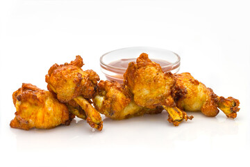 Five chicken wings isolated on white background, served with bbq sauce in glass bowl. Fried meat with sauce. Side view of Fast food dish. Menu isolation.