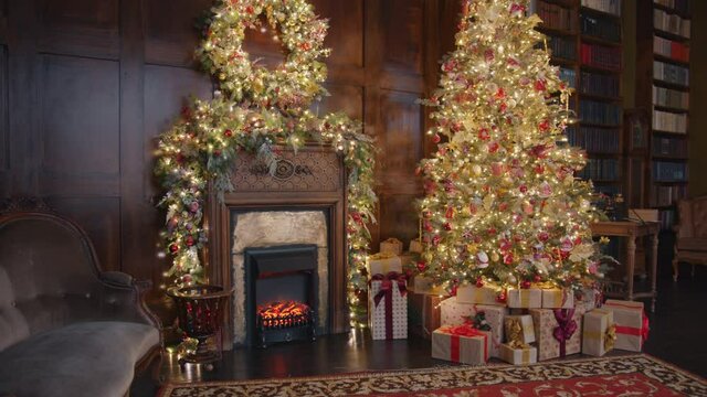 Beautiful cozy room with decorated Christmas tree, gifts and fireplace on New Year Day, no people are visible. Home and celebrations concept.