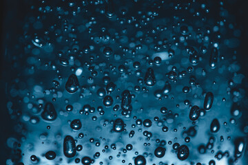 Bubbles of different shapes in dark blue color, water droplets and abstract background. Bubbles pattern and illumination