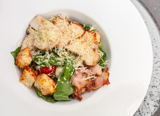 Caesar salad with shrimps in black plate