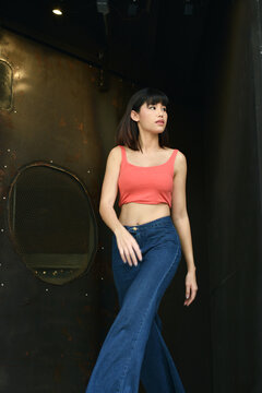 Portrait cool asian girl, Beautiful young asian woman in pink sleeveless shirt and wide leg blue jeans. She has slim body and tall. Fashion in summer