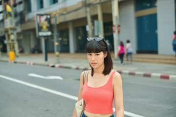 Beautiful young asian woman walking on the street and Blur background of urban cityscape.