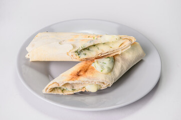 Georgian traditional Grilled rolls of lavash bread (pita) with suluguni cheese and green herbs (dill). picnic lunch food on gray serving plate on colorful background.

