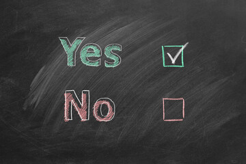 Two voting checkboxes with lettering Yes and No on blackboard. Check mark near Yes. Your choice concept.