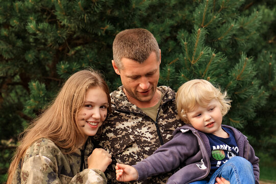 Father And His Children In Camouflage Ready To Play In Laser Tag Shooting Game Outside. Concept Of Father's Day, Military War Game, Father's Return Home.