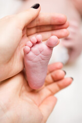 Baby foot in mothers hands