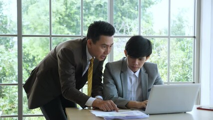 Business & Team work concept. Handheld, medium shot of senior manager coaching, guiding, giving support to junior employee to solve problem.